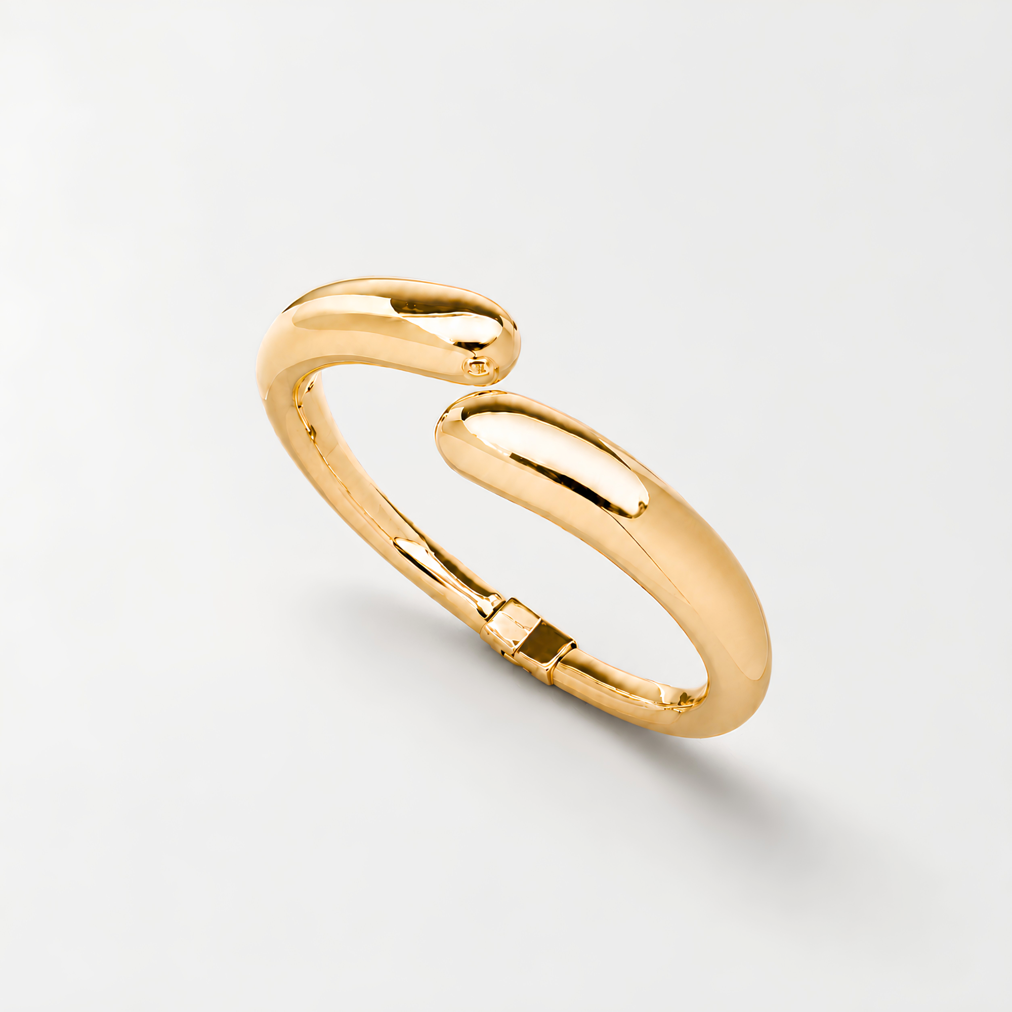 Gold open cuff bangle bracelet for women featuring a sleek polished finish and modern sculptural teardrop ends on a white background.