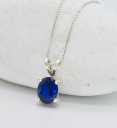 925 Sterling Silver necklace with Sapphire September birthstone in oval cut and prong setting. Solitaire pendant ideal gift for her, and for everyday wear. Blue sapphire pendant encourages truth, mental clarity, and spiritual insight. For wisdom, loyalty, focus