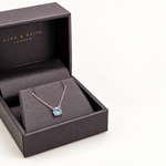 Sky blue topaz pendant necklace in Aura and Faith presentation box, angled view