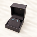 Sky blue topaz stud earrings presented in Aura and Faith box