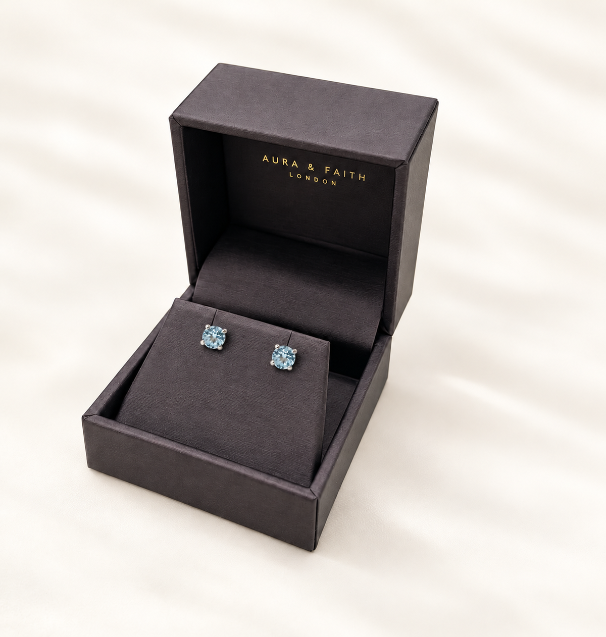 Sky blue topaz stud earrings presented in Aura and Faith box