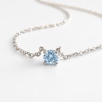 Blue topaz pendant necklace with white gold chain, angled view