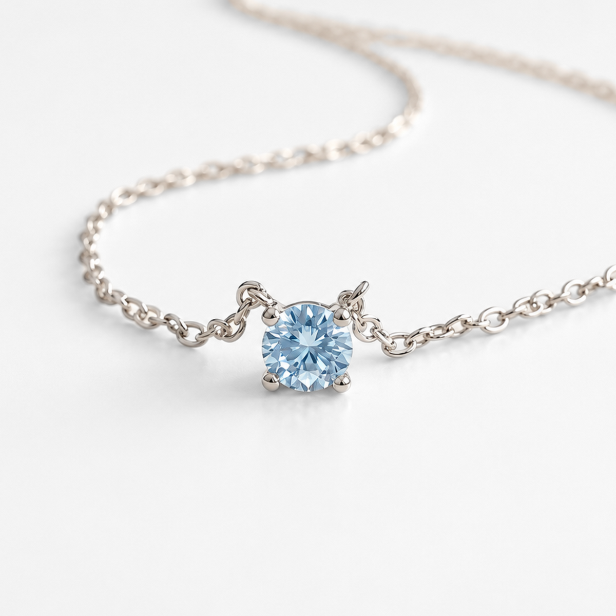 Blue topaz pendant necklace with white gold chain, angled view