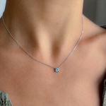 Blue topaz white gold necklace worn at the collarbone