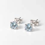 Pair of round blue topaz white gold stud earrings, angled view