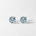 Pair of round sky blue topaz stud earrings in white gold, front view