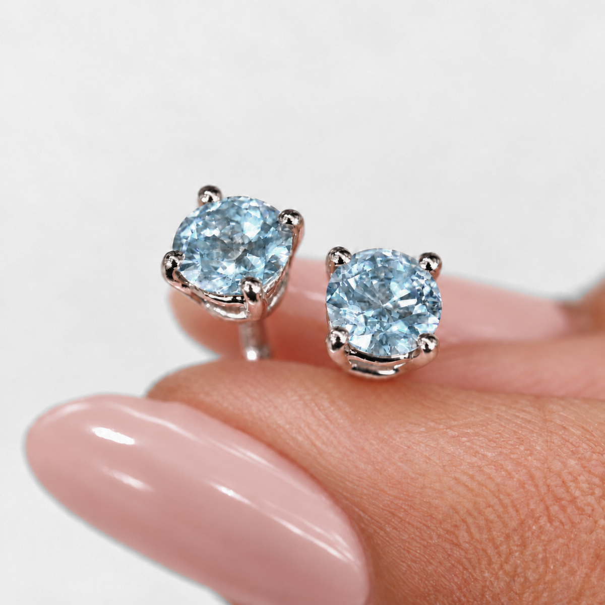 Blue topaz stud earrings shown for scale