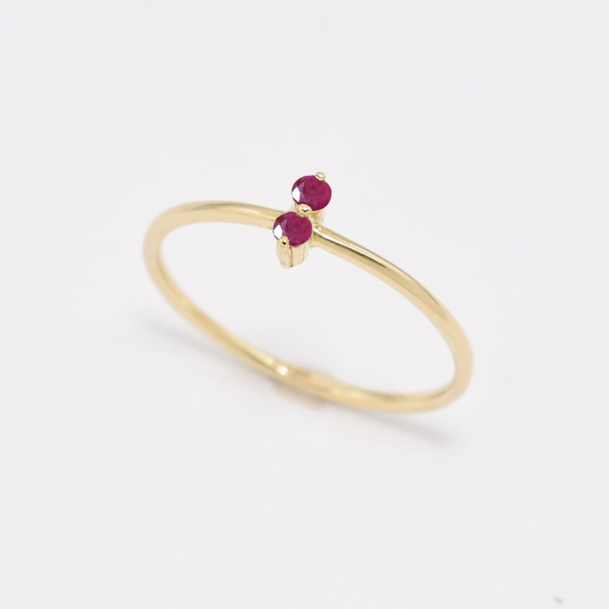 Side view of Aura & Faith dainty two-stone 14k gold ring, shown with rubies