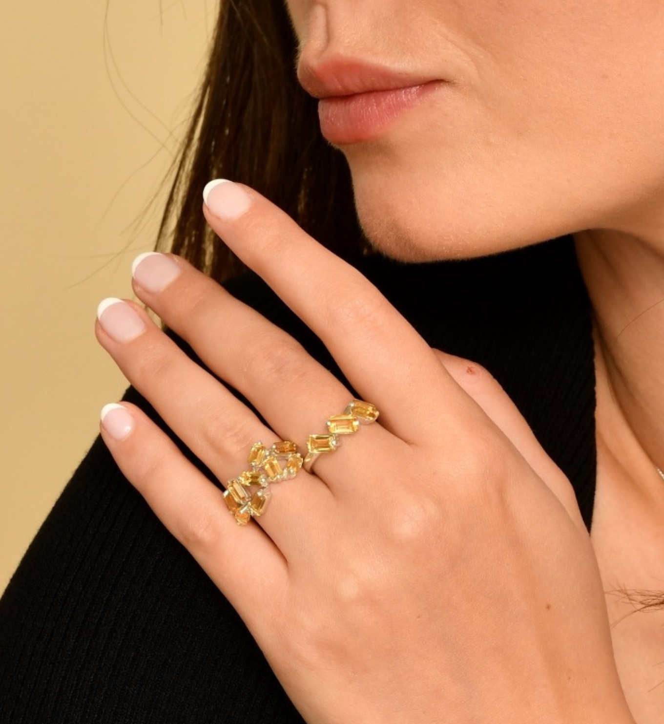 Woman wearing gold citrine rings, in baguette cut and prong setting. November birthstone ring for joy, abundance, confidence. 